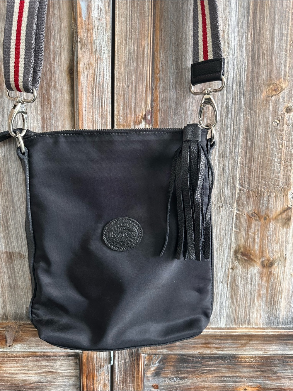 Roots Black Messenger Bag with Striped Strap and Tassel